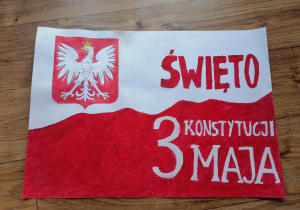 plakat autorstwa Aleksandry Koseli kl. VIIA (1) - na plakacie biało czerwona flaga, godło Polski i napis Święto Konstytucji 3 maja